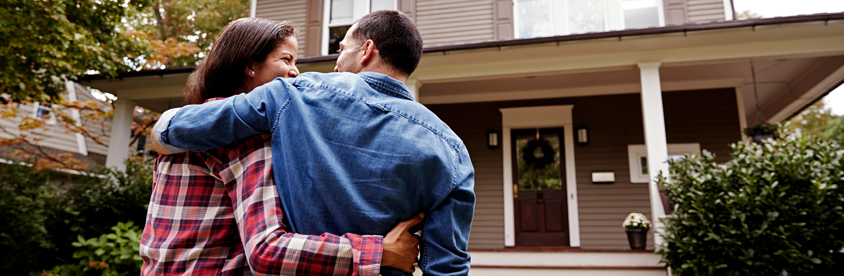 Smiling couple looking at their home